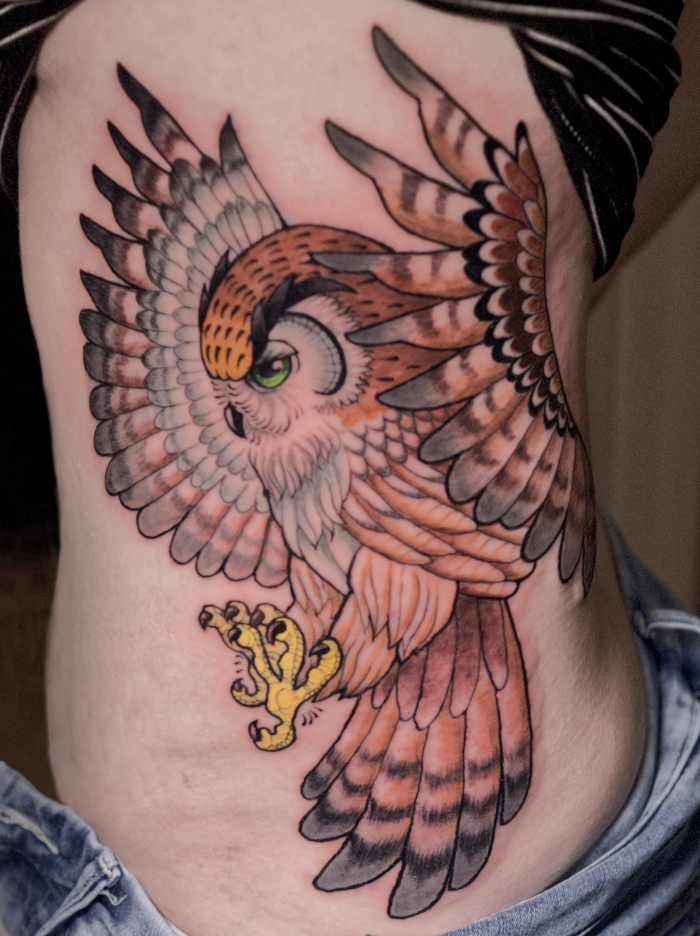 Neo traditional flying owl side tattoo with green eyes