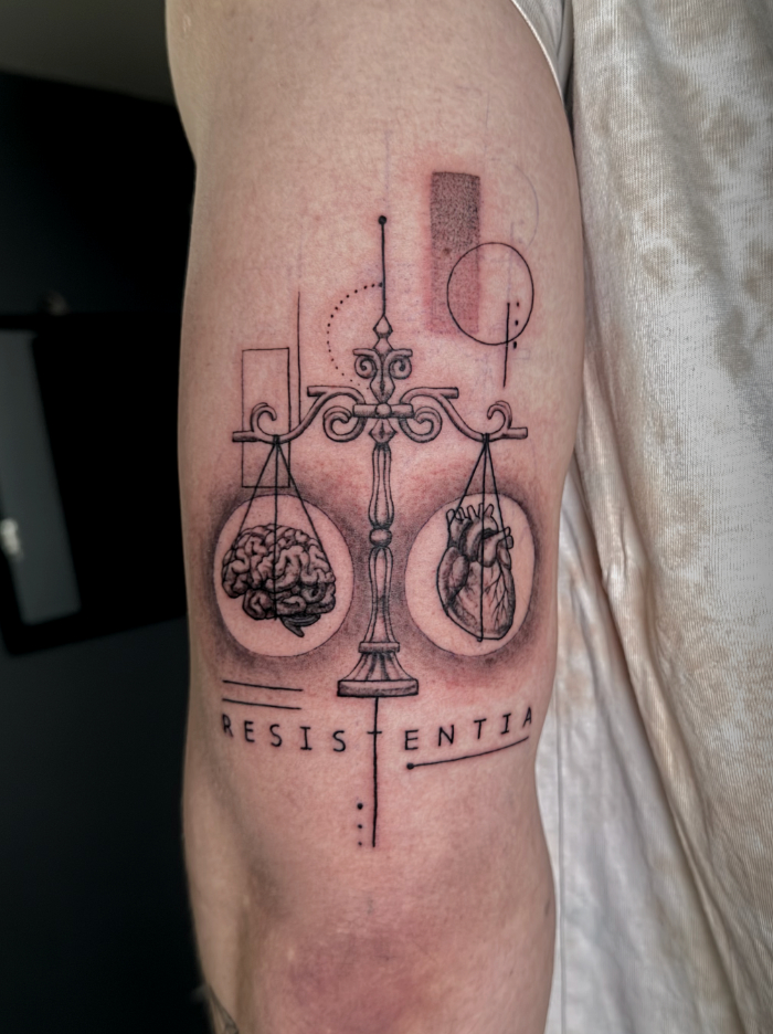 Minimalist scale tattoo balancing heart and brain Resistentia